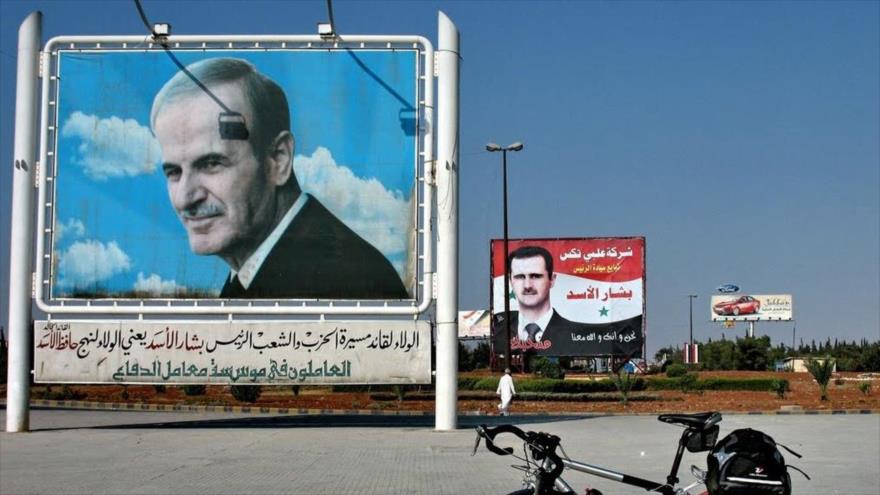 Dos carteles de imágenes del expresidente sirio Hafez al-Asad y el actual mandatario, Bashar al-Asad, en Siria.