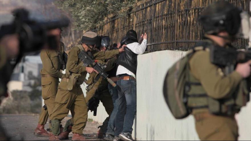 Los soldados israelíes detienen a dos palestinos en el pueblo de Silwad, en la ocupada Cisjordania, 17 de enero de 2014.