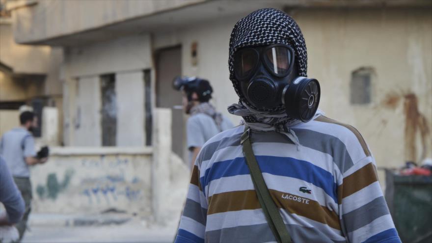 Ciudadanos sirios con máscaras antigas en una localidad en el norte del país.