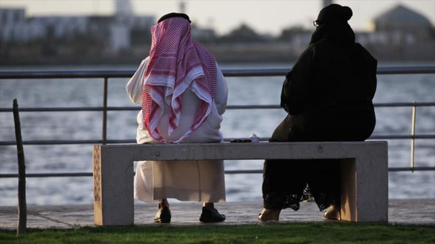 Una pareja saudí está sentada en un banco con vistas al mar, en Yeda, Arabia Saudí.