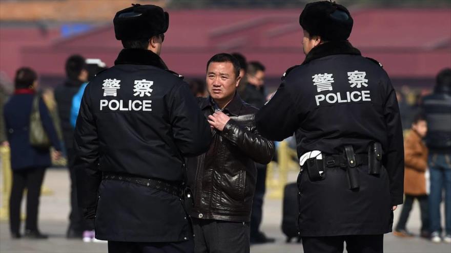 Policías chinos investigan a un hombre en la plaza de Tiananmén en Pekín, la capital, 2 de marzo de 2015.