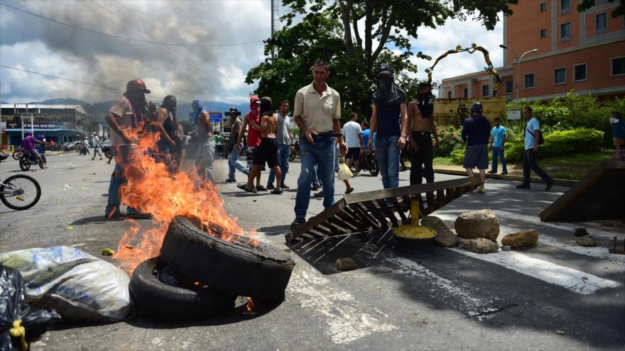 Os oponentes do governo venezuelano, Nicolás Maduro, queimam barricadas numa rua em Valência, Venezuela, 6 de agosto de 2017.