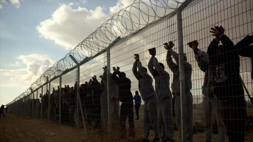 Inmigrantes africanos en el centro de detención de Holot mientras otros protestan frente al centro en el desierto del Négev, 17 de febrero de 2014.