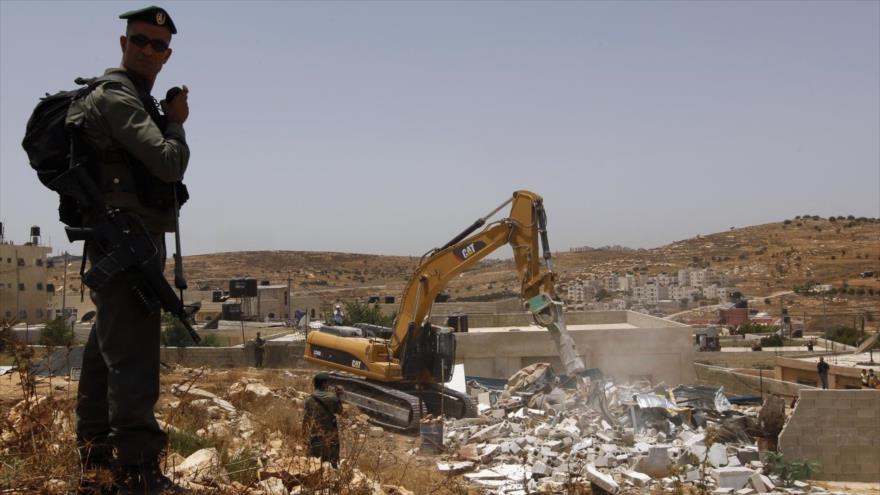 Fuerzas israelíes destruyen una casa palestina en los territorios ocupados palestinos.