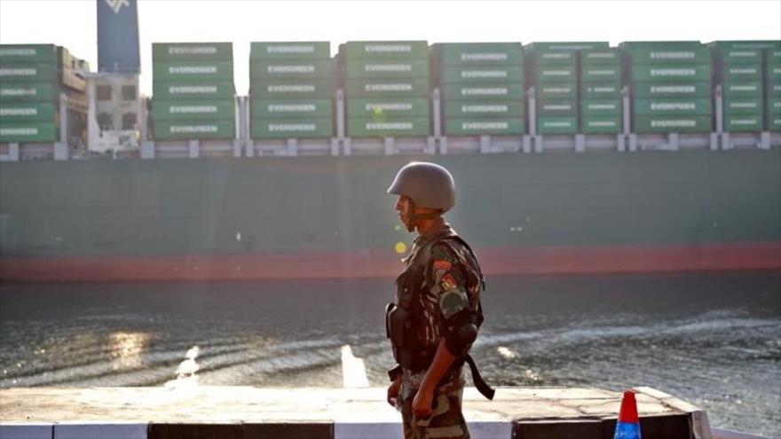 Un soldado egipcio está de guardia mientras un barco pasa a través del canal de Suez, 6 de agosto de 2015.