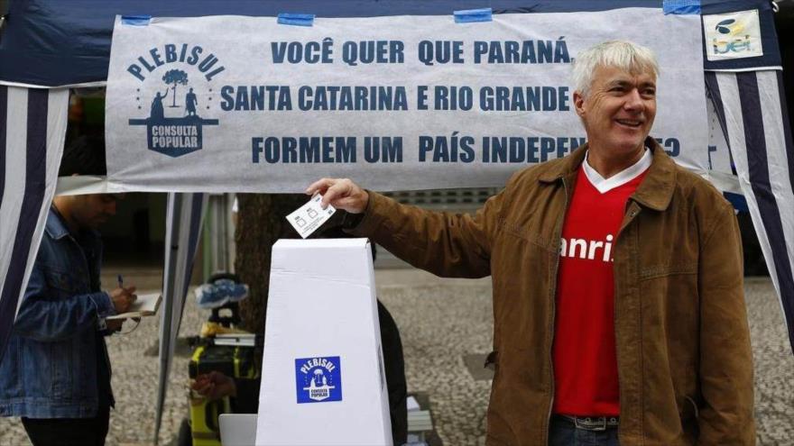 Un ciudadano brasileño deposita su voto en la urna en uno de los tres estados que realizan un referéndum separatista simbólico, 7 de octubre de 2017.