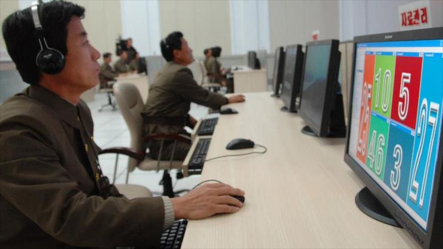 Científicos y técnicos norcoreanos trabajan en sus computadoras en el Centro General de Control y Mando de Satélites.