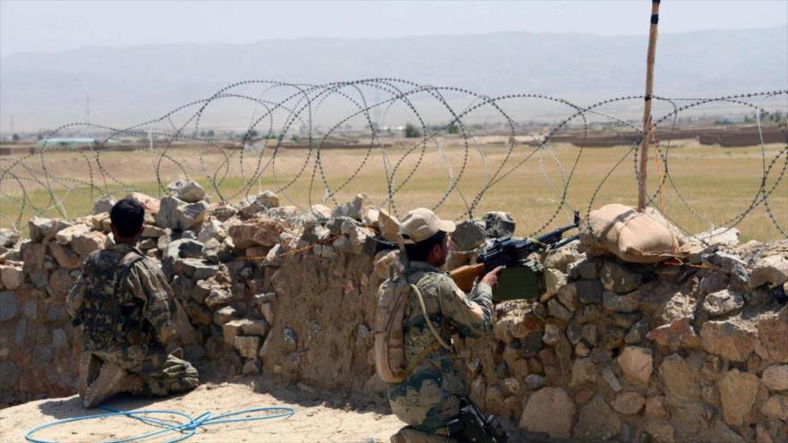 Soldados afganos montan guardia afuera de una base militar.