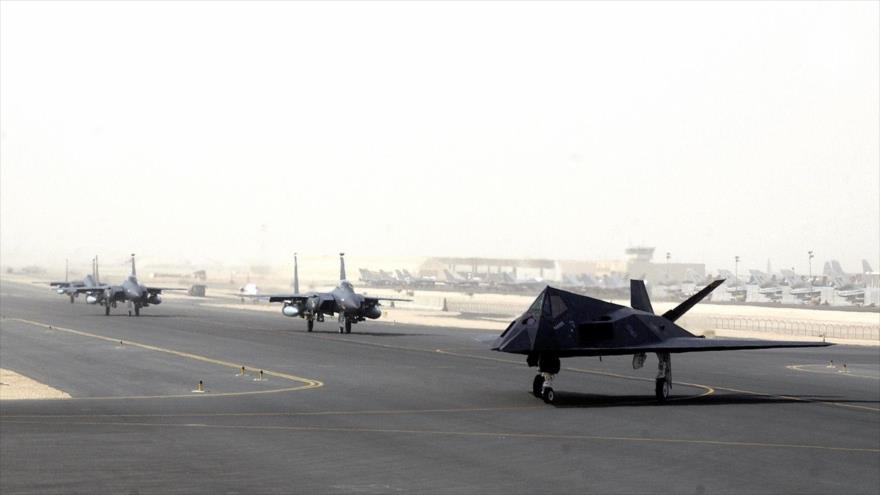 Un caza F-117 y varios cazas F-15 de EE.UU. se preparan para ensayos en la pista de la base aérea de Al-Udeid en Catar.