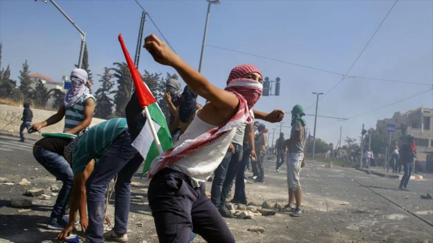Los palestinos atacan con piedras a las fuerzas israelíes en Shuafat, en Al-Quds (Jersusalén), 3 de julio de 2014.