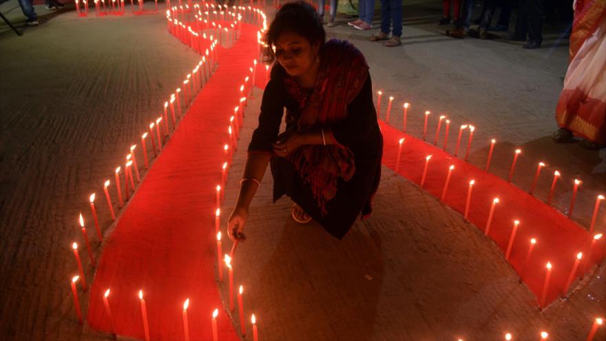 Una activista india enciende velas en forma de un lazo rojo, sÃ­mbolo internacional de la lucha contra el sida, 30 de septiembre de 2017.