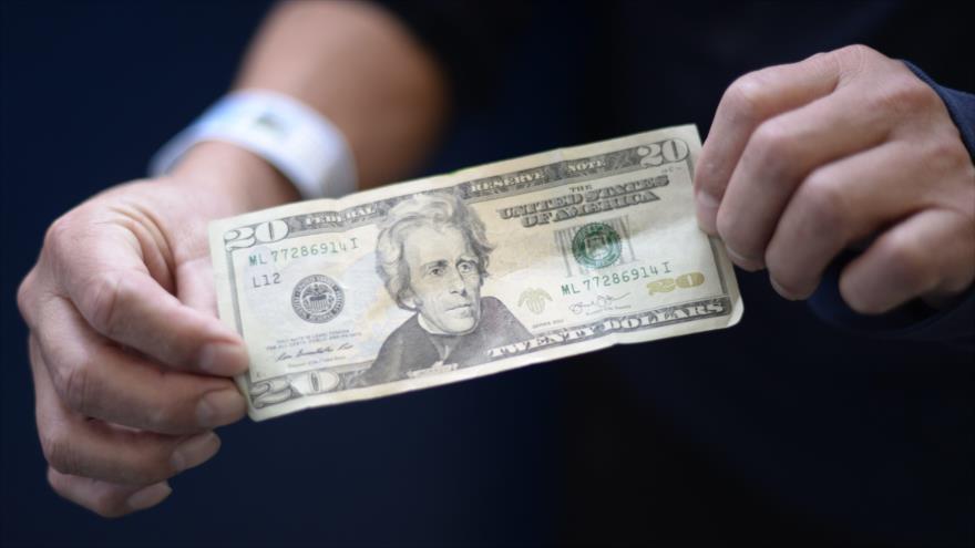 Un inmigrante deportado de Estados Unidos muestra un billete de 20 dólares antes de cambiarlo al llegar a Guatemala, 10 de enero de 2018.