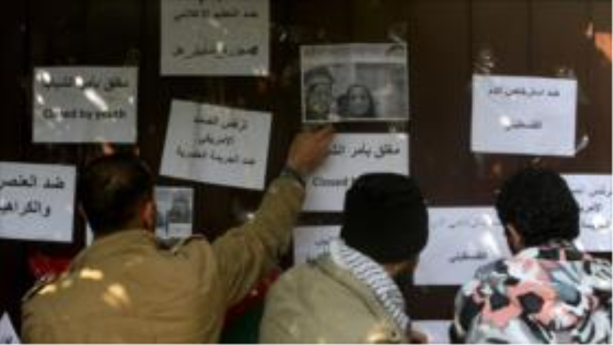 Jóvenes palestinos participan en un acto de protesta frente a la oficina de la institución estadounidense de CARE en Gaza en solidaridad con los tres estudiantes musulmanes asesinados en Carolina del Norte (EE.UU.), 16 de febrero de 2015