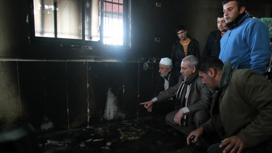 Un grupo de palestinos, entre ellos el clérigo Ibrahim Abu Luha, en una mezquita incendiada por los colonos israelíes en Cisjordania. 25 de febrero de 2015