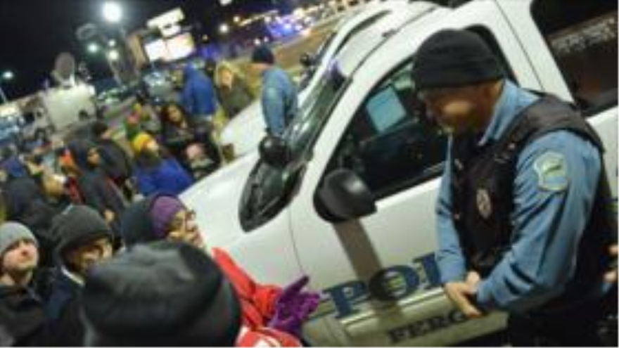 Activistas protestan ante el Departamento de Policía de Ferguson, Misuri, por la muerte de Michael Brown