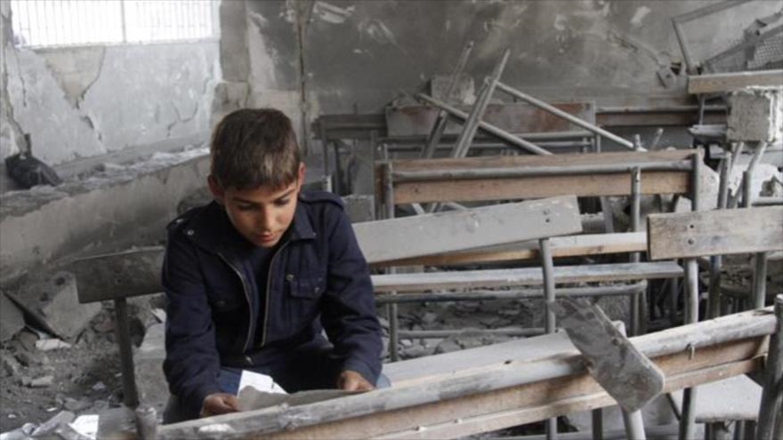 Niño sirio en una escuela destruida en Alepo, noroeste de Siria