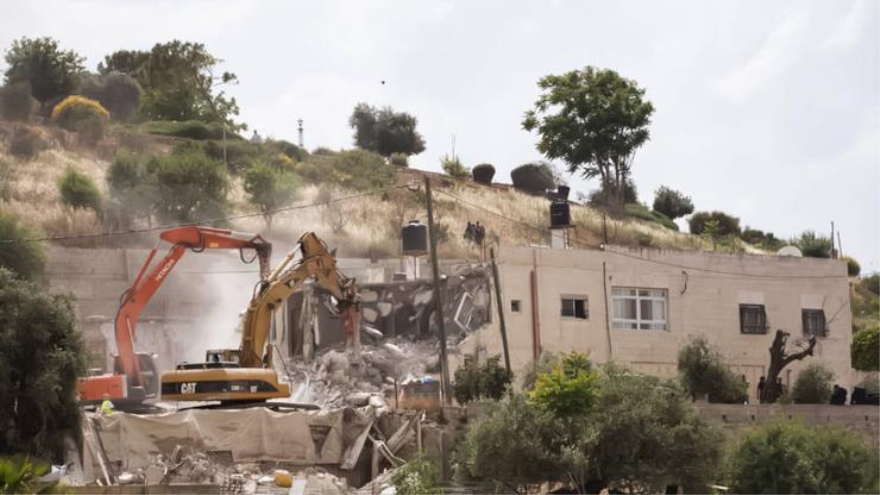 Excavadoras israelíes demoliendo viviendas palestinas en el barrio de Jabal Mukabbir en Al-Quds