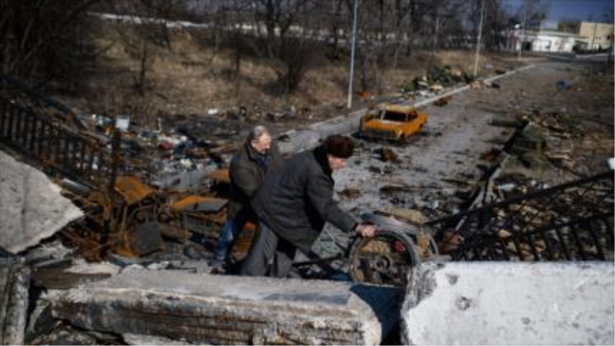 Dos hombres empujan un carro sobre un puente destruido cerca del aeropuerto de Donetsk, este de Ucrania. 