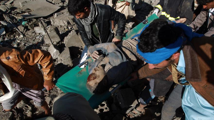 Civiles auxilian a un herido de ataque saudí en Yemen