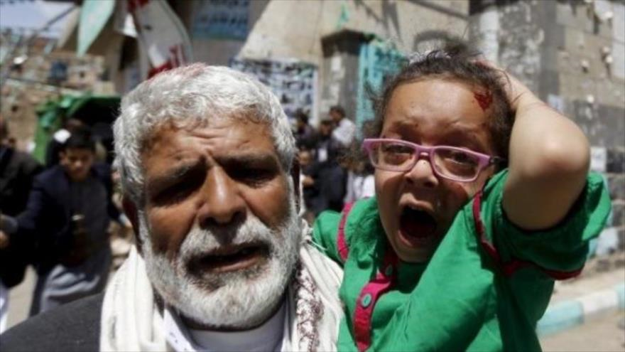 Una niña herida reacciona como ella es llevada por un hombre fuera de una mezquita en Saná, la capital yemení, que fue blanco de un ataque