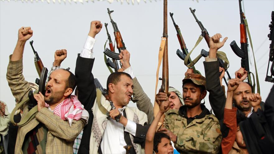 Combatientes del movimiento popular yemení Ansarolá blanden sus armas durante una manifestación contra los ataques aéreos saudíes en la capitalina ciudad de Saná.