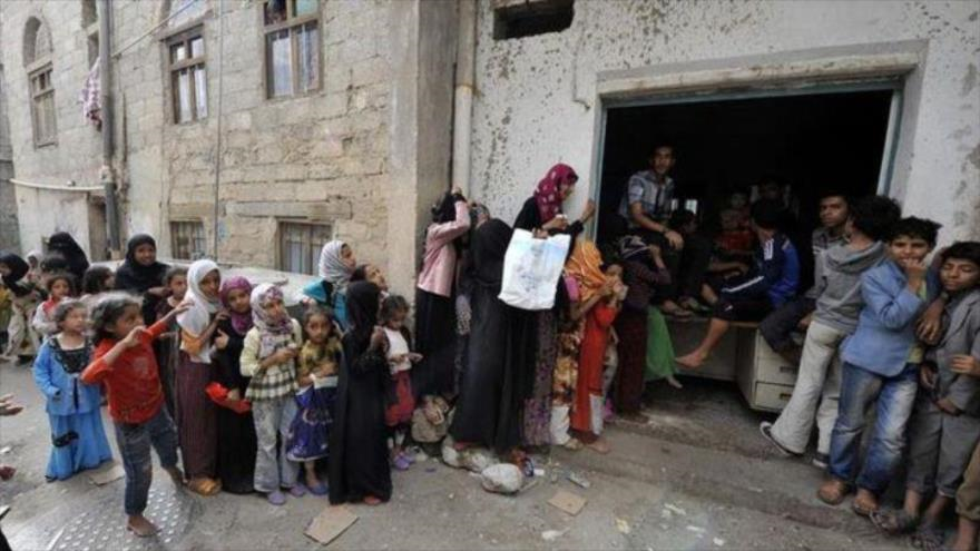 Un grupo de yemeníes intenta recibir ayuda humanitaria