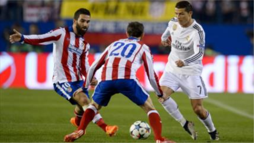 El delantero de Real Madrid Cristiano Ronaldo (drecha) compite con los centrocampistas de Atlético Arda Turan (izquierda) y Juanfran (centro). 14 de abril de 2015