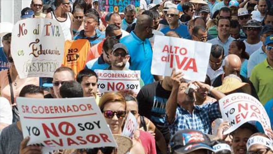 Manifestantes puertorriqueños muestran su rechazo al aumento de tasa de IVA