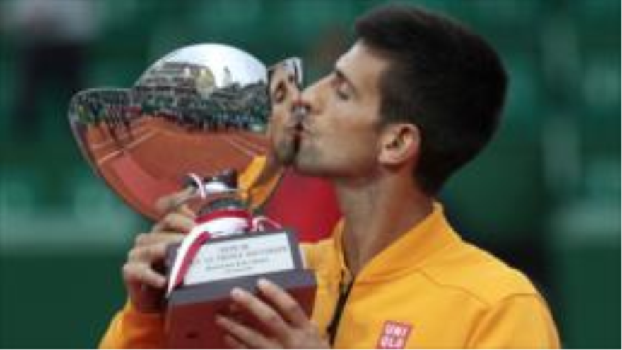 El tenista Novak Djokovic besa el trofeo de campeón del Masters de Montecarlo, 19 de abril de 2015