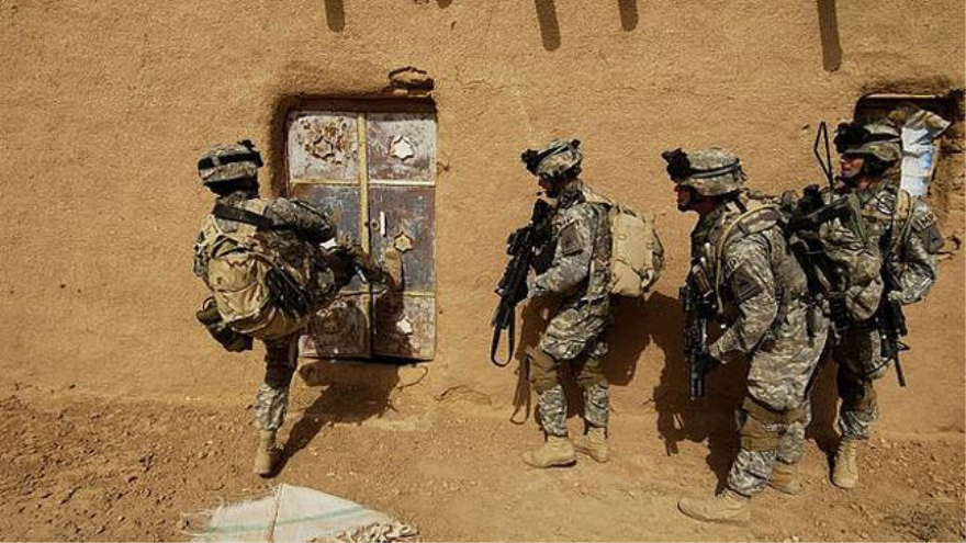 Soldados estadounidenses rompen la puerta de una casa durante una operación en Afganistán.