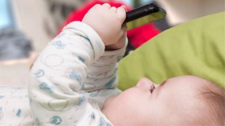 Un bebé está jugando con el móvil
