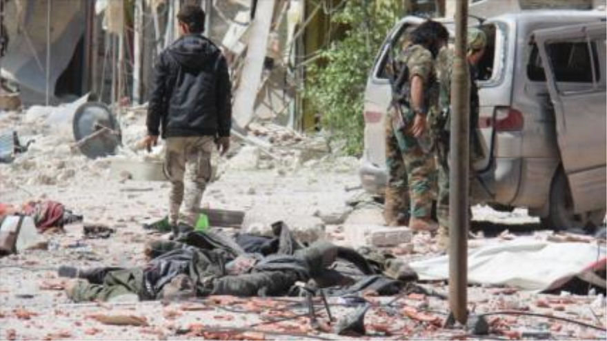 Elementos terroristas junto a presuntos cuerpos de los soldados sirios, en la ciudad siria de Yisr al-Shughur, en la provincia de Idlib (noroeste). 25 de abril de 2015
