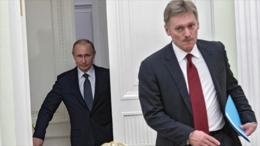 El portavoz del presidente ruso Vladimir Putin, Dimitri Peskov (en primer término), y el propio Putin, tras él