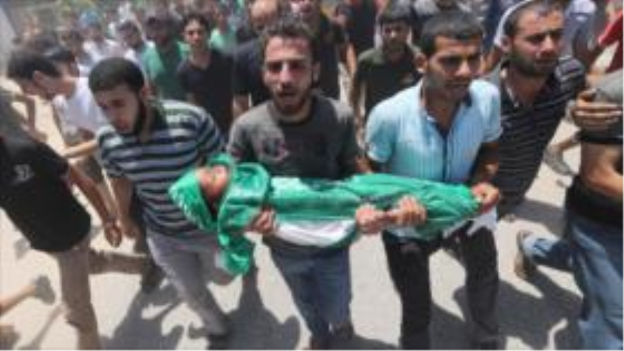 Los palestinos llevan al cementerio el cuerpo de un niño de 3 años de edad, quien perdió la vida en un ataque israelí al campo de refugiados de Maqazi, centro de la Franja de Gaza. 10 de julio 2014