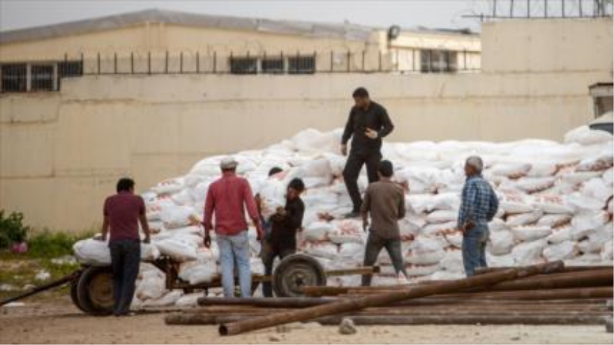 Obreros están cargando sacos de nitrato de amonio en el pueblo fronterizo de Akçakale, Turquía.