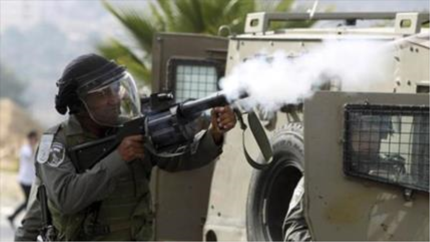 Soldado israelí dispara con su arma de fuego contra una manifestación de palestinos.