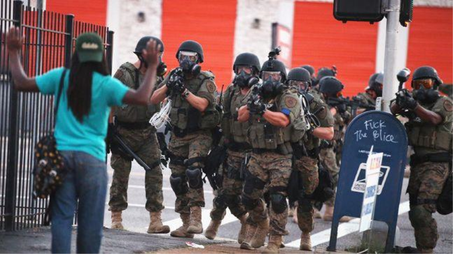Las fuerzas policiales caminan hacia un afroamericano durante las protestas en Ferguson, en Misuri, centro-este de EE.UU.