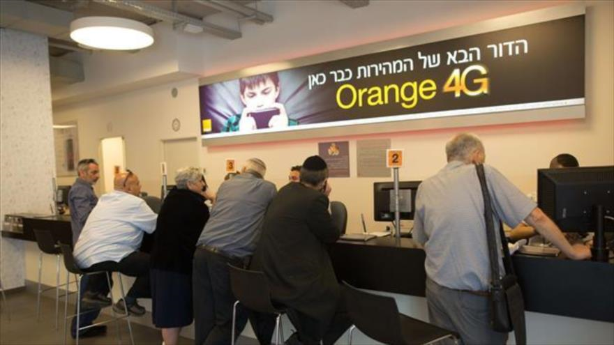 La foto muestra los colonos israelíes siendo ayudados por los asistentes en una tienda del operador de telecomunicaciones israelí Partner, que cuenta con una licencia de la compañía francesa Orange en los territorios ocupados palestinos.