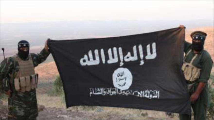 Bandera de Daesh en manos de dos miembros de este grupo terrorista en Afganistán.