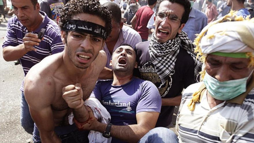 Partidarios de Mursi trasladan a un herido durante una protesta contra el Gobierno de Al-Sisi en El Cairo, capital de Egipto.