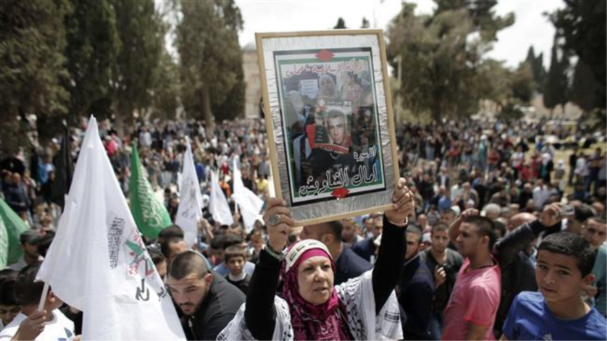 Una mujer palestina sostiene un retrato de un preso durante una manifestación que marca el Día del Prisionero palestino en Al-Quds. 17 de abril 2015