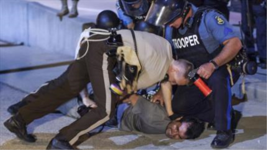 Los agentes policiales detienen a un manifestante durante una protesta en Ferguson