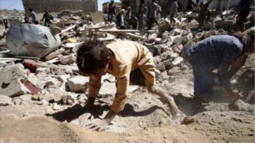 Niños yemeníes buscan sus pertenencias luego de un bombardeo saudí.