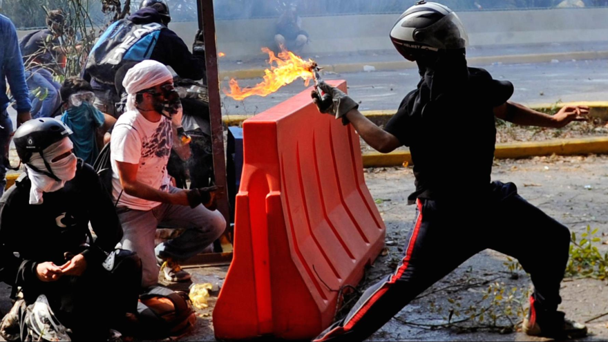 Opositores venezolanos lanzan cócteles molotov contra las fuerzas de seguridad durante una protesta antigubernamental en Caracas (capital).