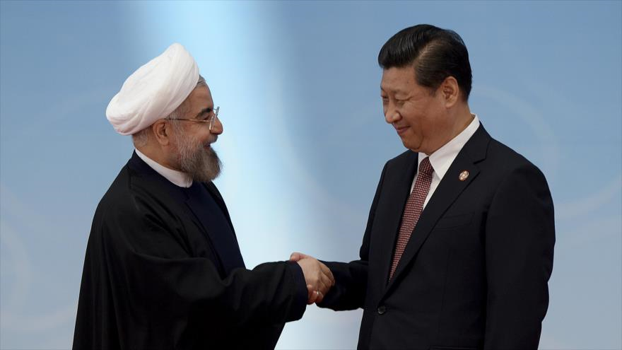 Presidente de Irán, Hasan Rohani (izquierda), estrecha la mano de su par chino, Xi Jinping (derecha).