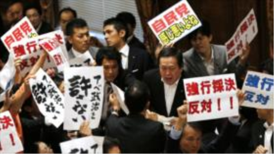 Los legisladores de la oposición en Japón rodean a Yasukazu Hamada, presidente del comité que votó en la polémica legislación de seguridad, en un intento de bloquear el proceso. 15 de julio.