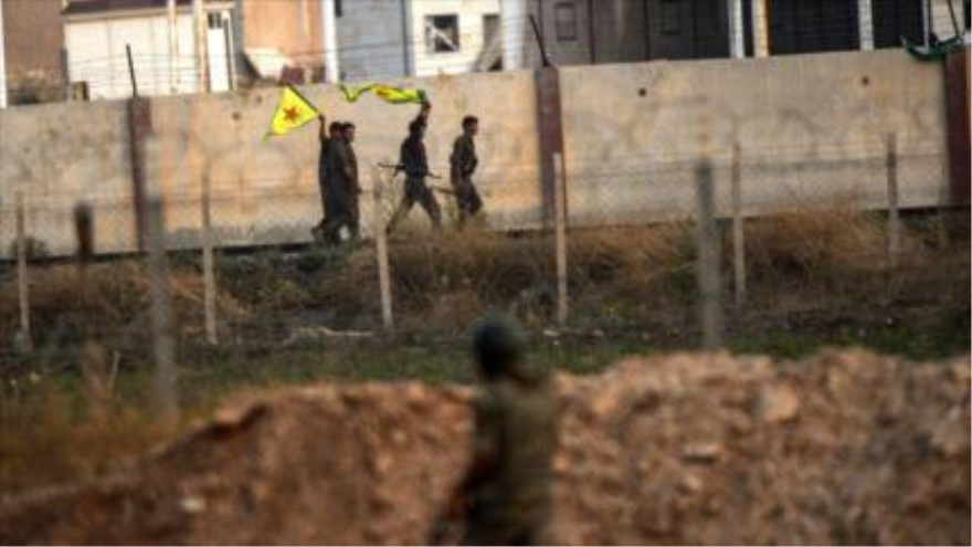 Un soldado turco observa cuatros combatientes de las Unidades de Protección Popular (YPG) en la frontera entre Turquía y Siria.