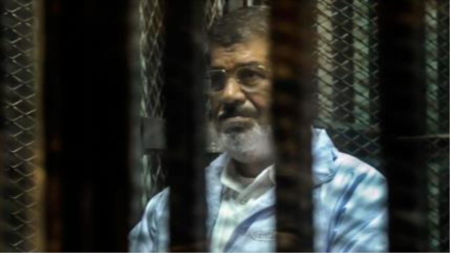 El expresidente de Egipto Mohamad Mursi, entre las rejas durante una sesión judicial.