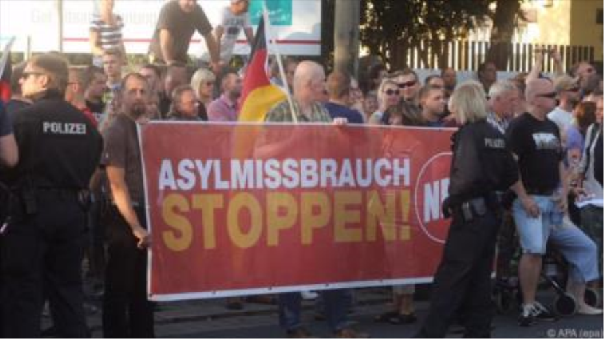 Manifestantes del Partido Nacional demócrata de Alemania (NPD por sus siglas en alemán) sostienen una pancarta que dice: Detengan el abuso de los asilos. 24 de julio 