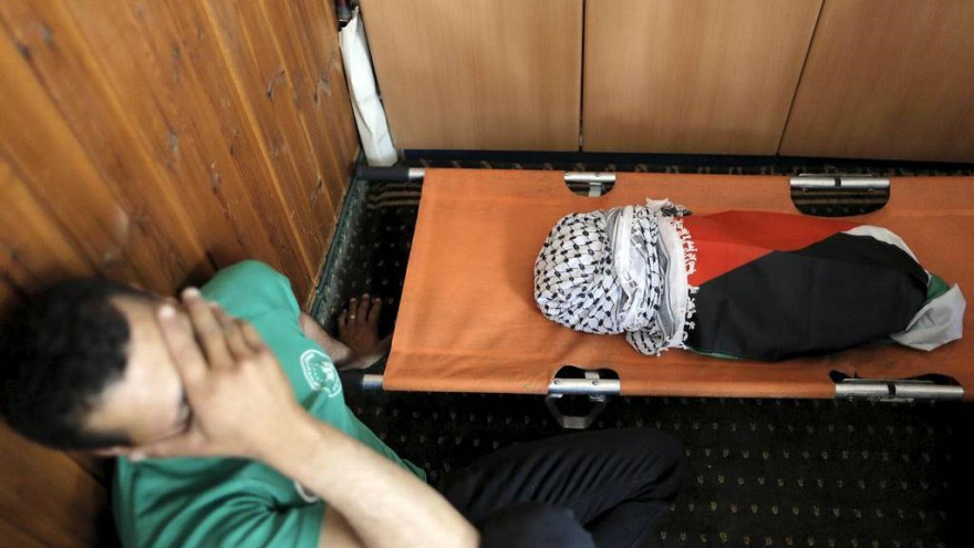 Familiar de un bebé palestino de 18 meses de edad llamado Ali Saad Dauabsha, que murió después de que su casa fuera incendiada por los colonos israelíes, lloran al lado de su cuerpo sin vida en la aldea cisjordana de Kafr Duma. 31 de julio 2015.